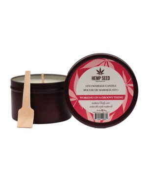 A 3-in-1 massage candle by Hemp Seed with the scent 'Working on a Groovy Thing', displayed with its lid off to the side and a small wooden spatula in front of it.