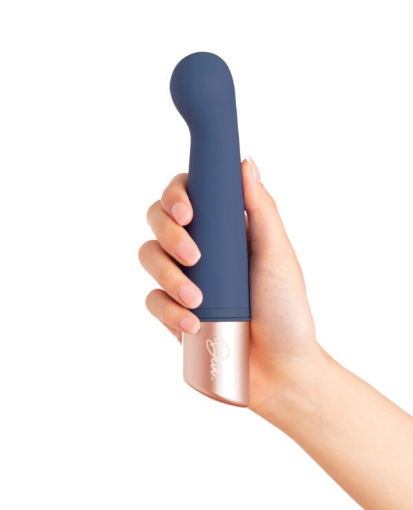 A hand holding a contemporary styled personal massager with a minimalist design, isolated on white background.