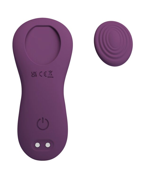 A purple handheld massager with a power button and charging ports, accompanied by a detachable massage head.