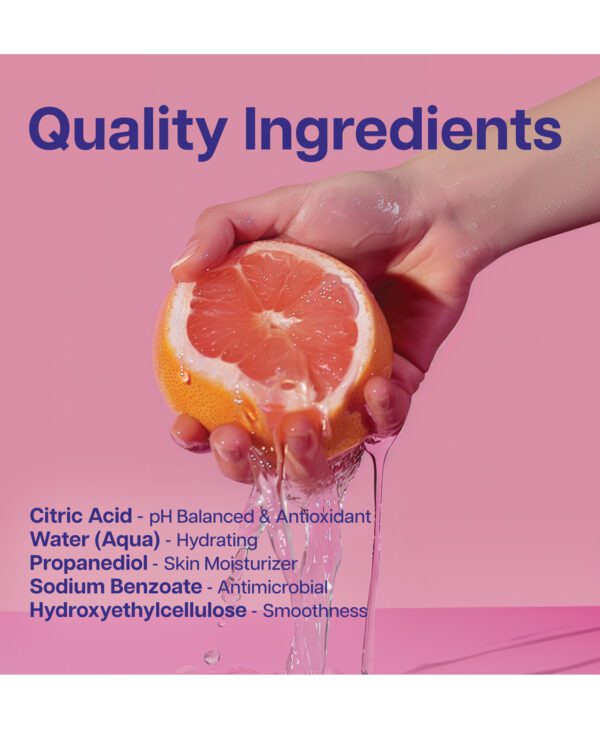 Hand squeezing a fresh grapefruit with water splashing, against a pink background with a list of skincare ingredients.