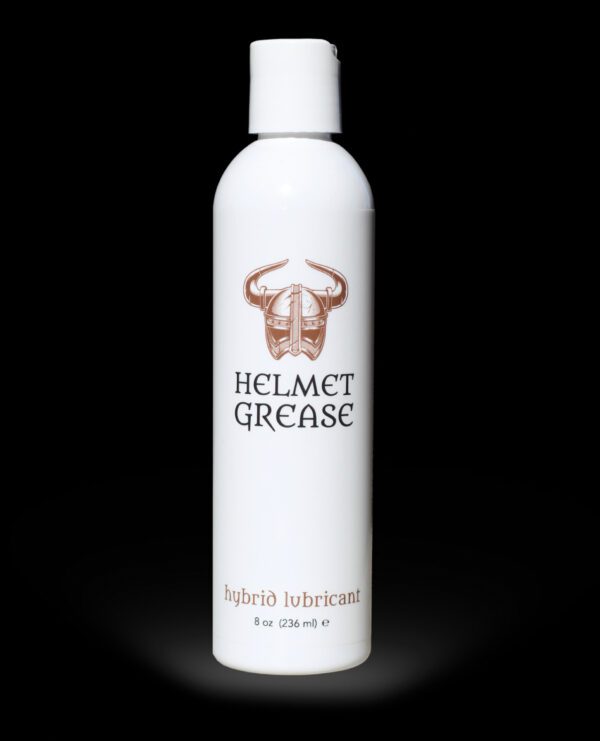 White bottle of Helmet Grease hybrid lubricant displayed against a black background.