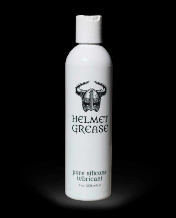 White bottle of Helmet Grease pure silicone lubricant against a black background