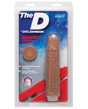 The image shows a packaged adult toy labeled "The D by Doc Johnson," described as a "Shakin' D Vibrating 7 Inch" with "Powerful Multi-Speed Vibrations," "Made from Dual Density ULTRASKYN," and a "Feel Me" sticker indicating the texture of the product.