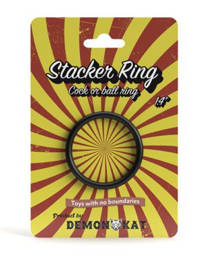 A package displaying a "Stacker Ring" adult toy with a sunburst yellow and red background, indicating it can be used as a "cock or ball ring," sized at 1/4", marked by the brand DemonIQ.