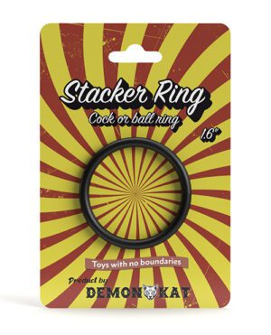 Alt text: Packaging for a "Stacker Ring" adult novelty item with a sunburst yellow and red background, featuring a black ring in the center and the text "Cock or ball ring .6'". The package is branded with "Toys with no boundaries" and the "Demoniq" logo at the bottom.