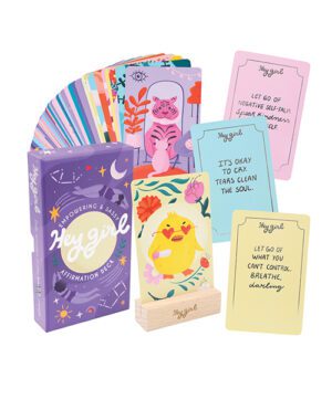 Colorful affirmation cards with inspirational quotes and illustrations spread out next to their packaging box labeled "Hey Girl Affirmation Deck".