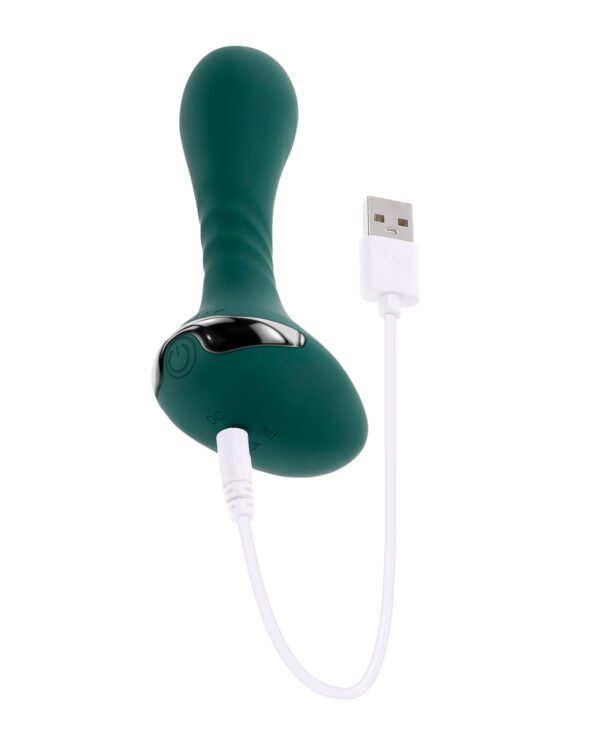 A green handheld electronic massager with a USB charging cable attached