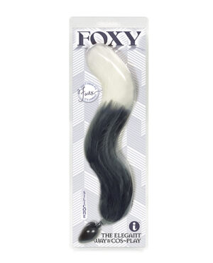 A packaged faux fox tail in black and white, with the word "FOXY" printed at the top and "THE ELEGANT WAY TO COS-PLAY" at the bottom.