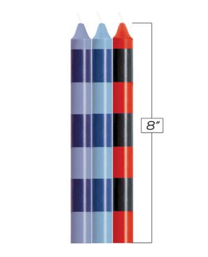 Four candles in different colors next to a ruler showing 8 inches in height