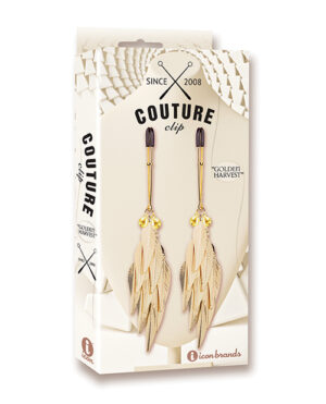 A pair of feather-shaped drop earrings with golden accents, displayed on a Couture Clips earring card.