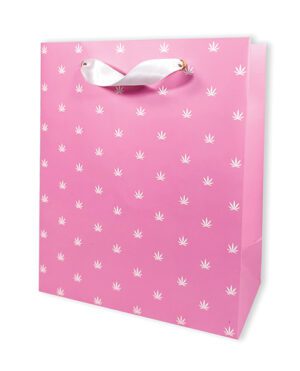 A pink paper gift bag adorned with a white leaf pattern and a white ribbon handle.