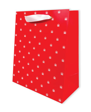 A vibrant red shopping bag adorned with a repeated white leaf motif, featuring a cut-out handle.