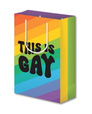A shopping bag with a rainbow striped design and the phrase "THIS IS GAY" written on the side in large black letters.