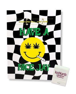 A playful greeting card with a smiling face, cannabis leaf graphics, checkered pattern, and a slot to insert a pre-rolled item, alongside a pack of matches.