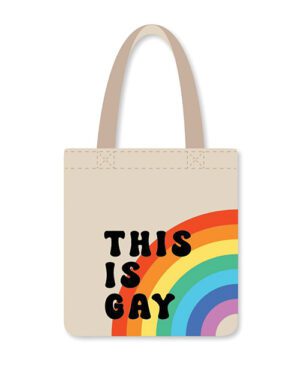 A tote bag with a rainbow graphic and the phrase "THIS IS GAY" printed on the front.