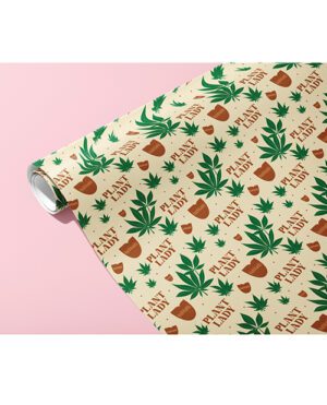 A roll of wrapping paper with a pattern of green plants and brown pots on a cream background, angled on a pink surface.