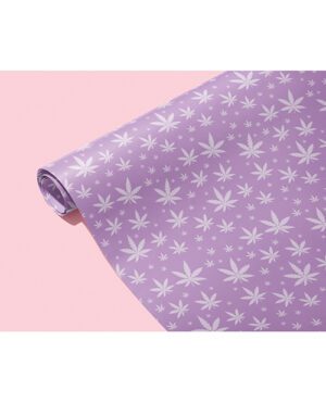 A roll of wallpaper with a leaf pattern displayed against a pink backdrop.