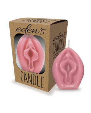 A pink candle shaped like a vulva, standing next to its packaging box with a window displaying the candle, labeled "eden's CANDLE".