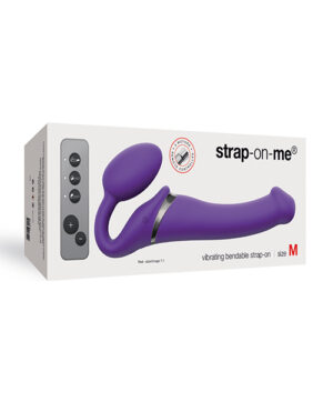 Strap-On-Me Vibrating Strap-On::A purple vibrating strap-on device in its packaging, labeled as size M and featuring control buttons on the side.