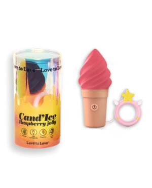 A raspberry jelly-scented candle in a colorful glass container alongside a pink ice cream cone-shaped object and a ring with a star attachment.