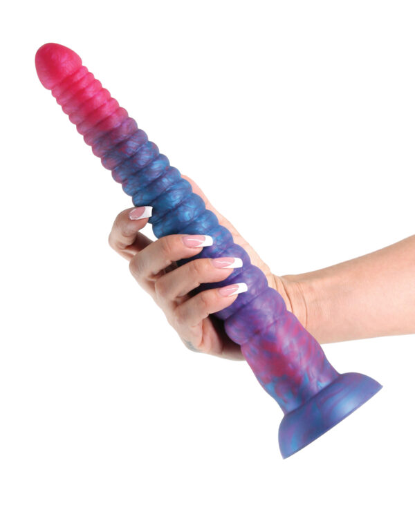 A hand holding a vibrant purple and pink silicone dildo featuring textured ridges and a suction base against a white background.