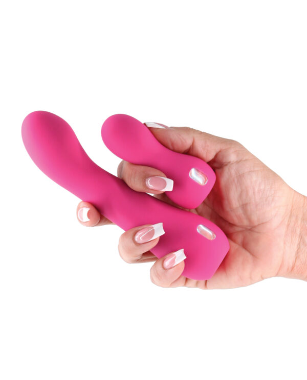 A hand holding two vibrant pink silicone massage toys, showcasing their smooth design and curved shapes against a white background.