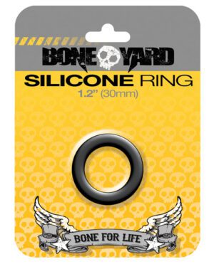 A product packaging for a "BONEYARD Silicone Ring" with a 1.2" (30mm) diameter displayed against a yellow background with skull patterns. The packaging features a stylized brand name at the top, a visible black silicone ring in the center, and the phrase "BONE FOR LIFE" flanked by winged graphics at the bottom.