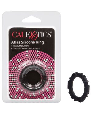 A packaged CalExotics Atlas Silicone Ring labeled as "premium silicone, stretchy and comfortable" on a pink and black dotted background, with the actual black silicone ring displayed beside the packaging.