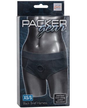 A product packaging of Packer Gear Black Brief Harness in size XS/S, featuring the brief in a plastic window display and promoting the ability to add your own dong and/or stimulator.