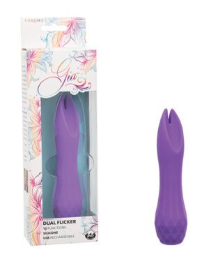 Alt text: A purple silicone personal massager by CalExotics, named "Gia", displayed next to its packaging, which states "Dual Flicker, 12 Functions, Silicone, USB Rechargeable". The product has a distinct split tip.