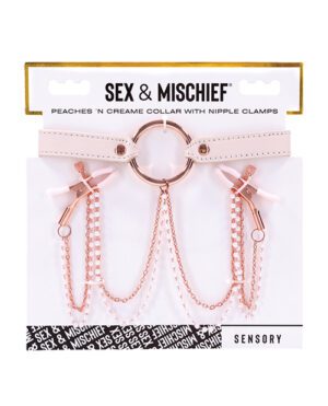Alt text: A product package featuring a "Sex & Mischief Peaches 'N Creame Collar with Nipple Clamps," which includes a pale pink collar with a central metal ring and attached chains leading to two metal nipple clamps, against a white background with brand logos.