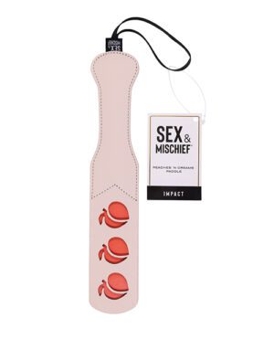 A pink paddle with three raised peach shapes, a black loop at the handle, and a tag reading "Sex & Mischief Peaches N' Creamme Paddle IMPACT".