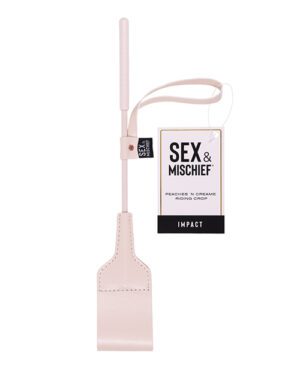 A pink riding crop with a wrist loop and a tag that reads "SEX & MISCHIEF PEACHES N' CREAME RIDING CROP."