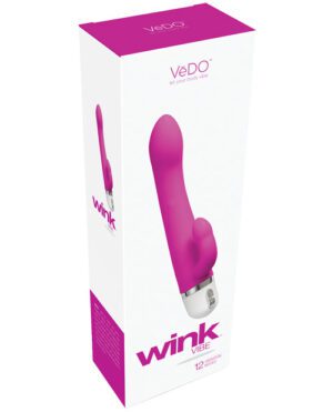 This image shows a product packaging for a VeDO wink vibrator. The package is predominantly white with purple accents, and it features an image of the pink vibrator. The text on the packaging includes the brand name 'VeDO', the slogan 'let your body vibe', and the product name 'wink'. Additional information indicates '12 speeds'.