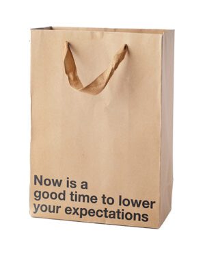 A brown paper bag with the phrase "Now is a good time to lower your expectations" printed on it.