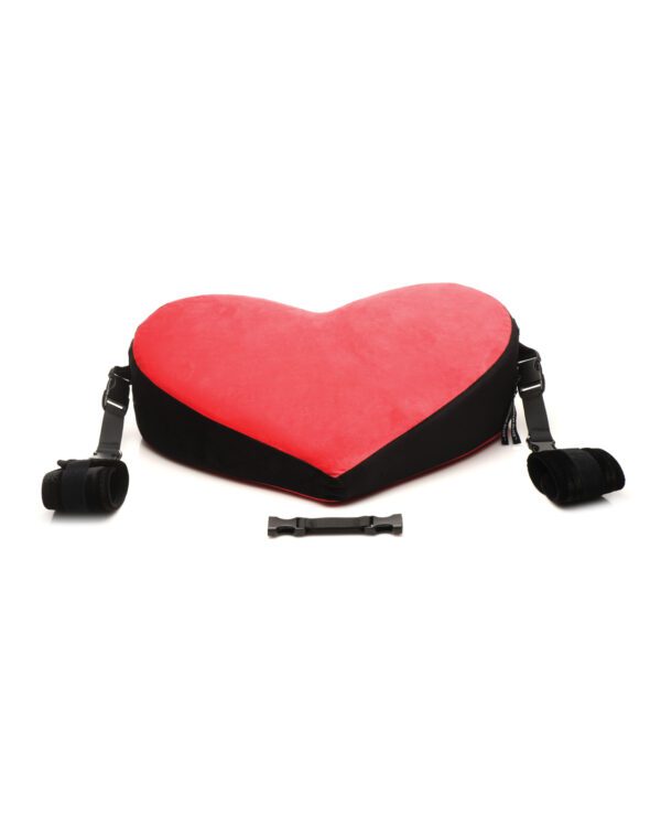 A large red heart-shaped pillow with adjustable black straps and a buckle, isolated on a white background.