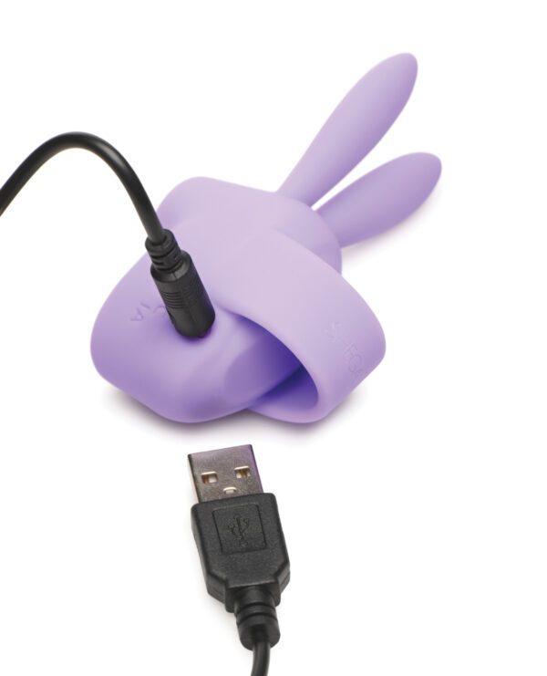 A USB cable plugged into a purple rechargeable device shaped like a rabbit, isolated on a white background