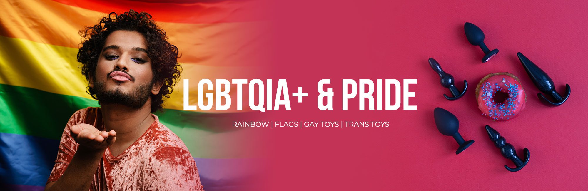 A banner featuring a person blowing a kiss in front of a rainbow flag on the left side, with the words "LGBTQIA+ & PRIDE" in large white font on a red background on the right side. Below the text, various black-shaped silicone items and a sprinkled pink donut are arranged on the red surface.